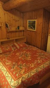 um quarto com uma cama num quarto de madeira em Mansarda Vista lago a Campodolcino em Campodolcino