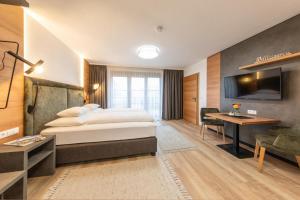 a hotel room with a bed and a desk and a television at Gasthof Rechenhof in Innsbruck