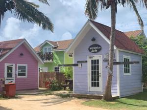 une maison colorée avec un panneau indiquant le club sud dans l'établissement Bay Inn Estates, à Alice Town