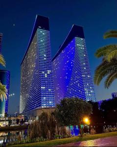 a large building with purple lights on it at night at Orbi City Sea View Apartments in Batumi