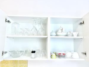 une armoire blanche remplie de vaisselle et de vases dans l'établissement Villa Sabine, à Merano