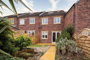 a brick house with wicker chairs in a garden at Stunning 3BD Home Hillsborough Sheffield in Sheffield