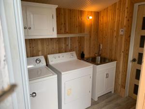 a small kitchen with white appliances and a sink at Les terrasses st aimé in Saint Aime Des Lacs +33 photos