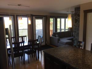 a living room with a couch and a table and chairs at Les terrasses st aimé in Saint Aime Des Lacs