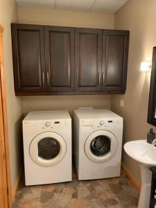 a laundry room with a washing machine and a washer at Les terrasses st aimé in Saint Aime Des Lacs