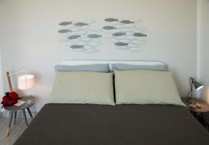 トッレ・サン・ジョヴァンニ・ウジェントにあるAppartamento Mare Verdeのベッドルーム1室(枕2つ、壁付)