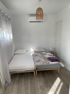 uma cama num quarto com uma parede branca em Maison Fleurs de Lys, climatisée, WiFi et Parking Privée Gratuit, Lave-Linge, Vernon Giverny em Vernon