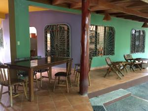 une salle à manger avec des murs verts, des tables et des chaises en bois dans l'établissement Villa Tortuga, à Nosara