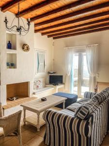 un soggiorno con divano e tavolo di Mykonos Dot - The Villas a Mykonos Città