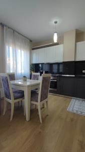 a kitchen with a white table and chairs in a kitchen at Tirana New Bazaar-Apartment 1 in Tirana