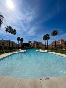 una grande piscina con palme e case di Casa Baviera Golf & Beach a Caleta de Velez