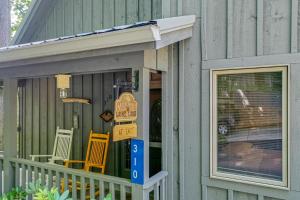 un porche con sillas y carteles en una casa en Laurel Lodge At Last en Townsend