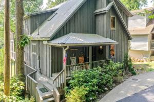 a green building with a porch and an american flag at Laurel Lodge At Last in Townsend