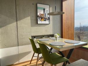 una sala da pranzo con tavolo e sedie verdi di *BRANDNEW* MODERNES APARTMENT IN DEN WEINBERGEN MIT POOL UND SAUNA a Spielfeld
