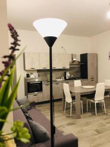 a kitchen and dining room with a table and a floor lamp at Casa Inyco in Menfi