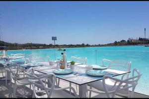 stół z białymi krzesłami i basen z wodą w obiekcie Alcazaba Blue Lagoon 3 bedroom, Ground floor Apartment w mieście Estepona