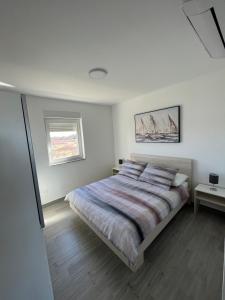 - une chambre blanche avec un lit et une fenêtre dans l'établissement Apartman - Kera Nin, à Nin