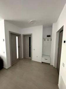 an empty room with white walls and a room with two doors at Central river apartment in Cluj-Napoca