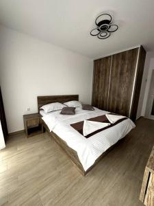 a bedroom with a large bed with a wooden headboard at Central river apartment in Cluj-Napoca