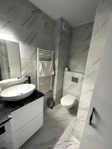 a white bathroom with a sink and a toilet at Central river apartment in Cluj-Napoca