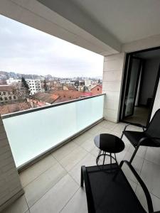 a balcony with a chair and a view of a city at Central river apartment in Cluj-Napoca