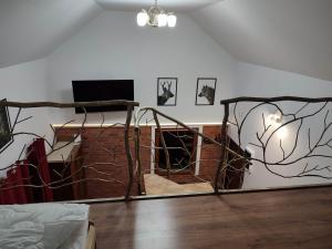 a living room with a staircase and a wall with wires at Domek pod sosnami in Gaj