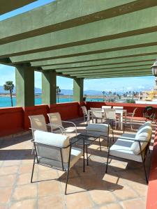 grupa krzeseł i stołów na patio w obiekcie Gibraltar Views Guest House w mieście La Línea de la Concepción