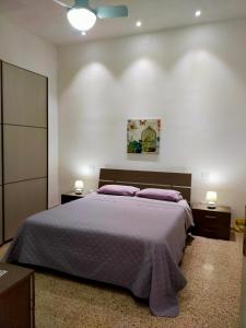una camera da letto con un grande letto con cuscini viola di Casa Margherita Airport Birgi a Guarrato