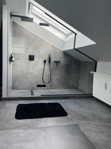 La salle de bains est pourvue d'une douche et d'un tapis noir. dans l'établissement New Yorker lejlighed, à Aarhus