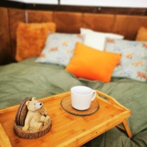 un ours en peluche assis sur une table avec une tasse de café dans l'établissement Perníková chalúpka, à Bojnice