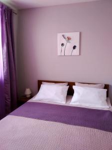 - une chambre avec un lit doté d'oreillers blancs et d'une photo dans l'établissement Baltijos 12b Apartamentai, à Klaipėda