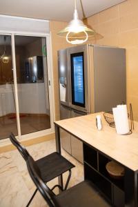a kitchen with a table and a chair and a refrigerator at AeroChic in Nouaceur