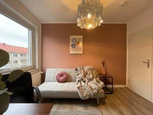 uma sala de estar com um sofá e um lustre em Apartment Strauss #DREI 3 Zi BS-Nordstadt em Braunschweig
