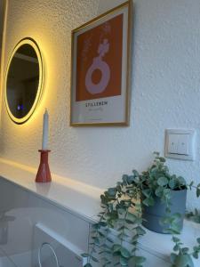 uma mesa com uma vela e uma imagem e uma planta em vasos em Apartment Strauss #DREI 3 Zi BS-Nordstadt em Braunschweig