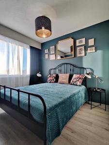1 dormitorio con 1 cama con paredes azules y espejo en Sweet family apartments Hamina, en Hamina