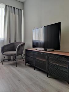 a living room with a television and a chair at Sweet family apartments Hamina in Hamina