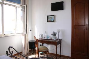 アグリジェントにあるLa Finestra sulla Valleのテーブル、椅子、窓が備わる客室です。