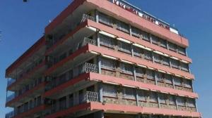 ein hohes rotes Gebäude mit Balkonen darauf in der Unterkunft Kakamega Town Guest House in Kakamega