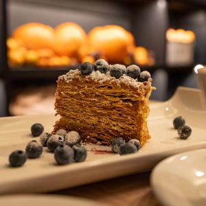 un trozo de pastel con arándanos en un plato en Mercure Concepcion, en Concepción