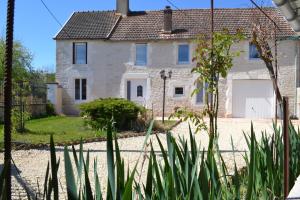 a stone house with a garage in front of it at La Villa de Jeanne in Les Riceys