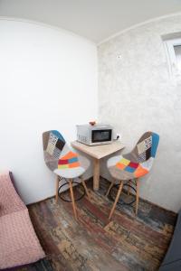 ein kleines Zimmer mit einem Tisch und 2 Stühlen in der Unterkunft SibiuStayCentral in Sibiu