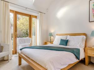 Un dormitorio con una cama grande y una ventana en The Old Stables en Kirkton of Tealing