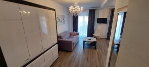 a living room with a couch and a chandelier at Holiday apartments Cecilija in Supetarska Draga