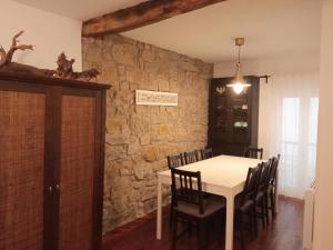 a dining room with a white table and chairs at Taosa - ONGI ETORRI in Zumaia