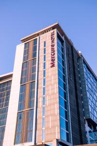 a tall building with a sign on it at Mercure Concepcion in Concepción