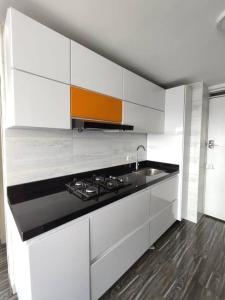 a white kitchen with a stove and a sink at Apartamento embajada americana in Bogotá