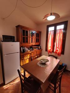 Una cocina con una mesa y un refrigerador blanco. en L'Appartamentino, en Lucca