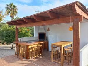 an outdoor kitchen with wooden tables and stools at Villa Finca Sol Javea in Jávea