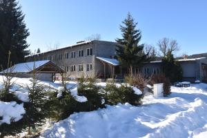 un edificio con la neve davanti di Apartmány IMLADRIS, Hotel u pralesa a Benešov nad Černou