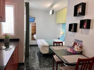 a room with a bed and a kitchen with a table at Estudios Dalia in Vecindario